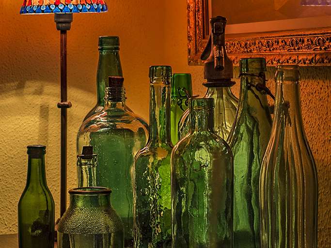 REUNIÓN CLANDESTINA DE BOTELLAS A LA LUZ DE UNA LÁMPARA